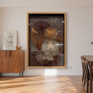 Op de afbeelding: Een groot rechthoekig wandkunstwerk met meerdere cirkelvormige draadkunstformaties in bruin-, goud- en crèmetinten, gevat in een lichthouten lijst. De ingewikkelde radiale patronen zijn geplaatst tegen een donkere achtergrond.