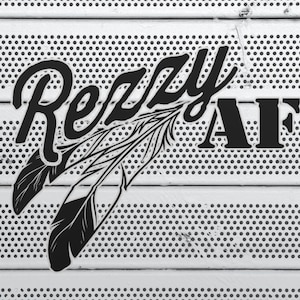 May include: Black and white graphic design featuring the word "Rezzy" in a stylized font, accompanied by the letters "AF" and two feathers. The design is set against a white background with a pattern of small, evenly spaced holes.