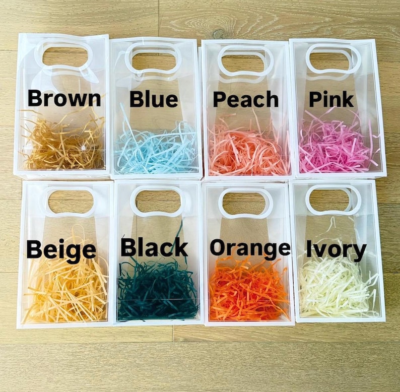 Peut inclure: Sacs cadeaux transparents remplis de papier d&eacute;chiquet&eacute; de diff&eacute;rentes couleurs : marron, bleu, p&ecirc;che, rose, beige, noir, orange et ivoire. Chaque sac est dot&eacute; d'une poign&eacute;e et d'une &eacute;tiquette de couleur.