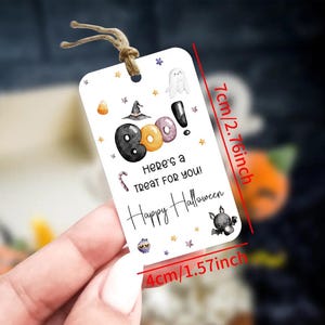 May include: A rectangular Halloween gift tag, 10 cm wide and 7 cm tall, with a string. The tag features the word "BOO!" with a witch hat, ghost, and bat illustrations. Text reads "Here's a TREAT FOR YOU! Happy Halloween."