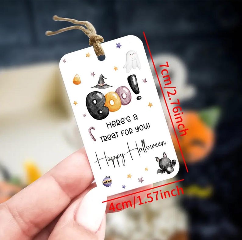 May include: A rectangular Halloween gift tag, 10 cm wide and 7 cm tall, with a string. The tag features the word "BOO!" with a witch hat, ghost, and bat illustrations. Text reads "Here's a TREAT FOR YOU! Happy Halloween."