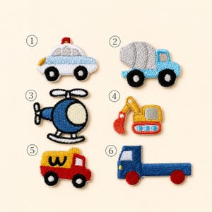 May include: Six embroidered patches featuring vehicles: a white and blue police car, a blue cement mixer, a blue helicopter, a yellow and red excavator, a yellow and red truck with a W, and a blue flatbed truck, all numbered one through six.