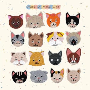 Puede incluir: Una colección de parches bordados con caras de gato en varios colores, incluyendo marrón, naranja, gris y negro. Los parches están dispuestos en filas y columnas, con el texto "HAVE A NICE DAY" encima.