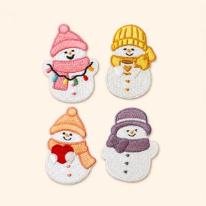 May include: Four embroidered snowman patches. The top left snowman wears a pink hat and scarf with colorful string lights. The top right snowman wears a yellow hat and scarf holding a mug. The bottom left wears an orange hat and scarf holding a red heart. The bottom right wears a purple hat and scarf.