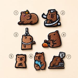 May include: Seven embroidered patches featuring brown capybaras in various activities, numbered one through seven. Designs include a capybara with a citrus fruit, wrapped in a towel, holding a tool, eating, meditating, holding a fish, and using a laptop.