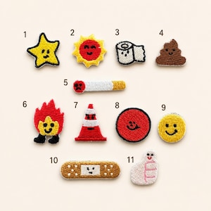May include: A collection of eleven embroidered patches featuring various icons including a yellow star, a red sun, a toilet paper roll, a brown pile, a cigarette, a flame, a traffic cone, a red circle, a yellow smiley face, a bandage, and a ghost.