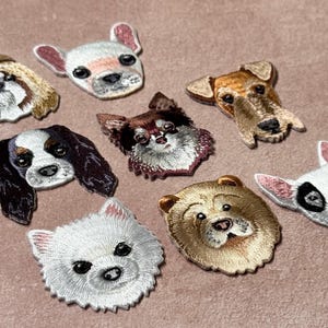 May include: A collection of embroidered dog breed patches, including a Shih Tzu, French Bulldog, Cavalier King Charles Spaniel, Chihuahua, Terrier, Pomeranian, Chow Chow, and Bull Terrier. Each patch has detailed features.