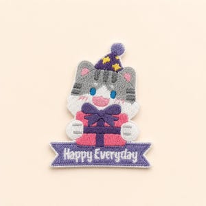 May include: An embroidered patch featuring a gray tabby cat wearing a purple party hat with yellow stars. The cat holds a pink gift box with a dark purple bow. Below the cat is a purple banner with the white text Happy Everyday.