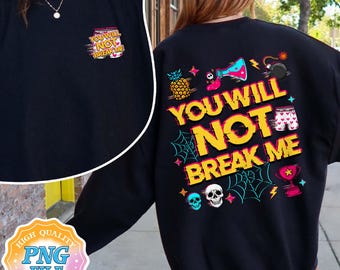 May include: Black sweatshirt with the text "YOU WILL NOT BREAK ME" in yellow and red. The design includes a pineapple, beaker, bomb, and other graphics. A smaller version of the text is on the front.