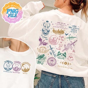 May include: White sweatshirt with a graphic print of various symbols and text. The text includes "There you are", "Light it Up", "Fire Breathing Bitch Queen", "To Whatever End", "Umbra Mortis", "Velaris City of Starlight", "Jnathion Light it Up", "What's Your Wingspan", "Thirteen", and "Don't let the hard days win".