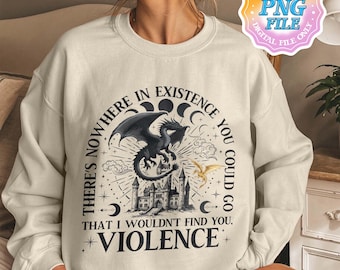 May include: A cream-colored sweatshirt with a black and gold graphic print of a dragon, a castle, and stars. The text on the graphic reads "There's nowhere in existence you could go that I wouldn't find you, Violence."
