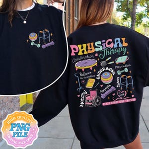May include: Black sweatshirt with a colorful "Physical Therapy" graphic on the back, featuring exercise equipment illustrations. The front has a small design with a dumbbell, exercise ball, and walker. "It's a great day to play" is also printed.
