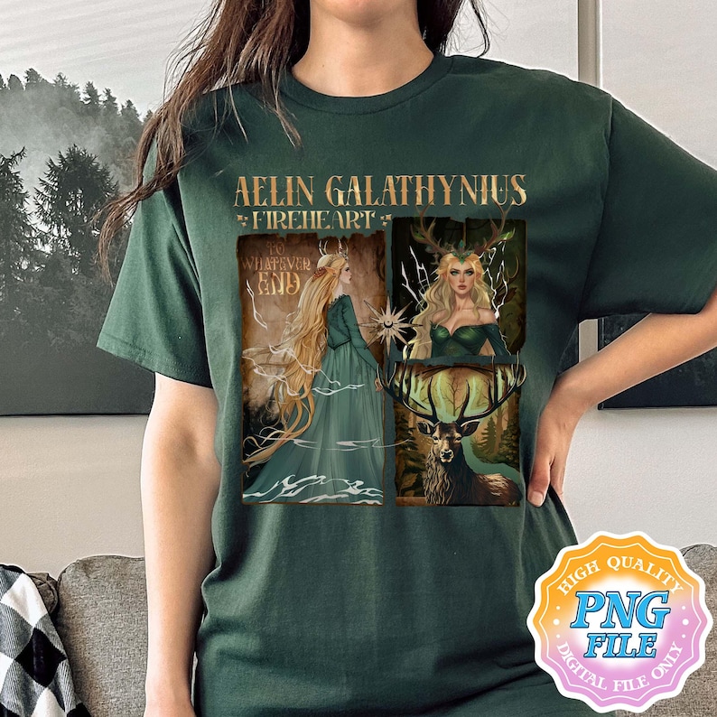 May include: Dark green t-shirt with a fantasy art design. The design includes the text "Aelin Galathynius Fireheart" and two illustrations of a woman with long blonde hair. One illustration shows the woman in a green dress, and the other shows her with a deer.