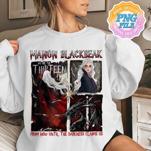 May include: A white sweatshirt with a graphic print of a woman with long white hair and the text "Manon Blackbeak We Are The Thirteen From Now Until The Darkness Claims Us".