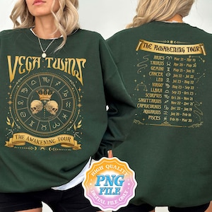 Puede incluir: Sudadera verde con texto y gráficos dorados. La parte delantera de la sudadera dice "VEGA TWINS" con una rueda del zodíaco y el texto "THE AWAKENING TOUR". La parte trasera de la sudadera tiene una lista de signos del zodíaco con sus fechas.