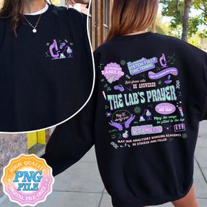 May include: Black sweatshirt with a science lab graphic on the front and back. The front features a microscope and lab equipment. The back has the text "THE LAB'S PRAYER" with scientific symbols and phrases like "May QC always pass" and "NOT HEMOLYZED".