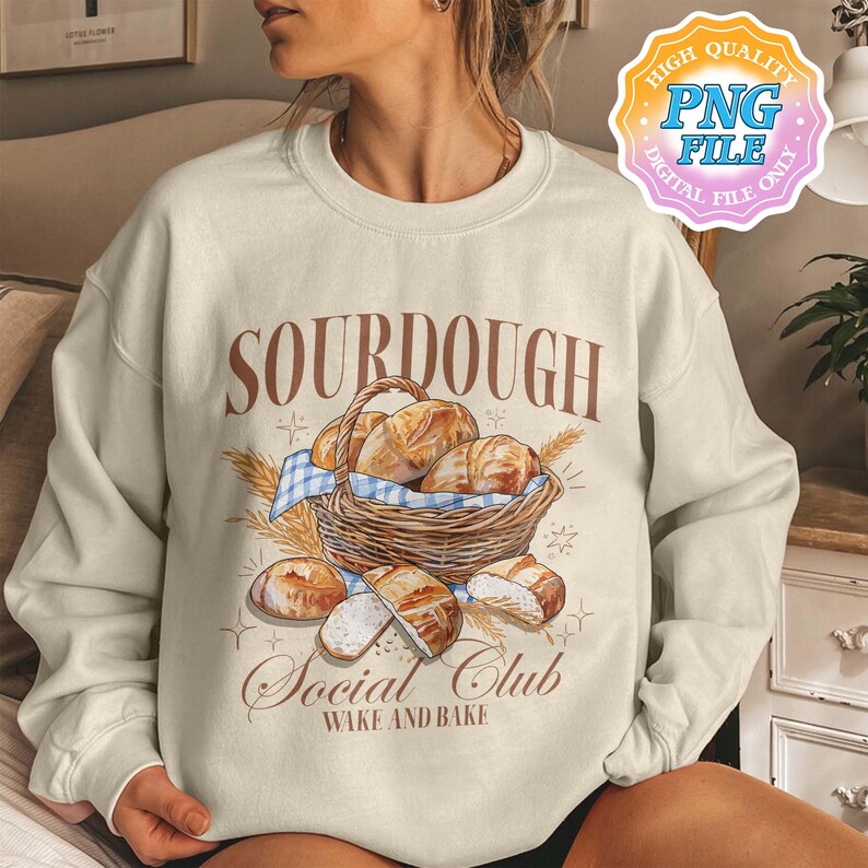May include: A beige sweatshirt with the text "SOURDOUGH Social Club Wake and Bake" and a graphic of a basket of sourdough bread.