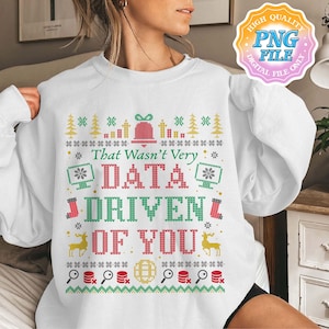 Può includere: Felpa bianca con un design festivo. Il design include una campana, alberi di Natale, fiocchi di neve e il testo "That Wasn't Very DATA DRIVEN OF YOU" in rosso e verde. La felpa ha girocollo e maniche lunghe.