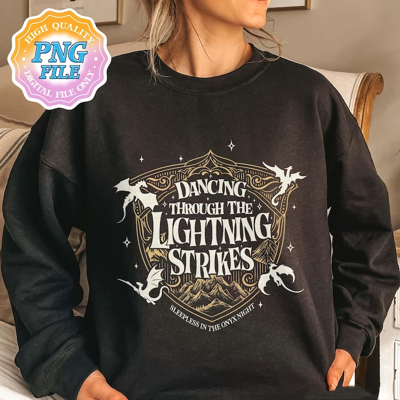 May include: Black sweatshirt with a gold and white graphic. The graphic reads "Dancing Through The Lightning Strikes" with dragon illustrations and the text "Sleepless in the Onyx Night".