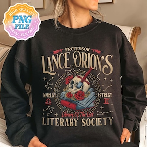 May include: Black sweatshirt with a vintage-style graphic design featuring a skull with a dagger, books, and the text "Professor Lance Orion's Library of the Lost Literary Society". The design includes stars, constellations, and the zodiac symbols for Libra and Gemini.