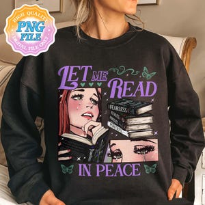 May include: Black sweatshirt with a graphic print of a woman reading a book. The text on the shirt says "Let me read in peace".