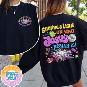 May include: Black sweatshirt with the text "Shining a Light on Who Jesus Really Is!" in colorful, stylized lettering. The design includes a disco ball, microphone, and other graphic elements. The front of the sweatshirt has a smaller version of the design.