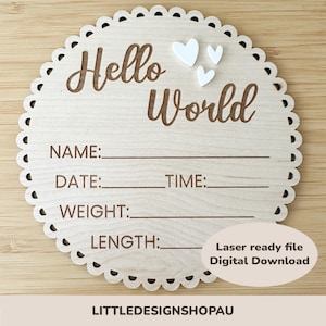 Puede incluir: Un círculo de madera blanco con un borde festoneado, que presenta el texto "Hello World" en letras marrones. El círculo tiene líneas en blanco para "Nombre", "Fecha", "Hora", "Peso" y "Longitud". Hay tres corazones blancos en la esquina superior derecha. El texto "Archivo listo para láser Descarga digital" está en la esquina inferior derecha. El texto "LITTLEDESIGNSHOPAU" está en el centro inferior.
