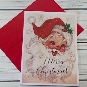 May include: A vintage Christmas card featuring a cartoon Santa Claus with a red hat and white beard. The card has a glittery background with snowflakes and stars. The text "Merry Christmas!" is written in black cursive lettering.