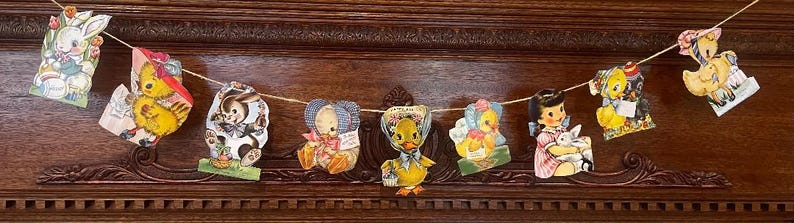 May include: A vintage Easter banner with a string of colorful paper cutouts featuring a bunny, chicks, and a cow. The banner is made of paper and has a rustic, vintage look.