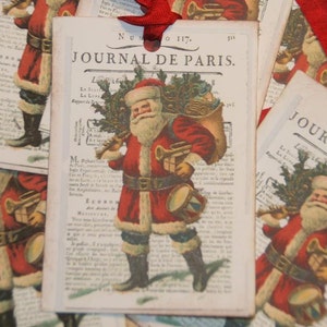 Pu&ograve; includere: Etichette regalo vintage di Natale con un'illustrazione rossa e bianca di Babbo Natale che porta un sacco di regali. Le etichette sono stampate con il testo "Journal de Paris" e un numero.