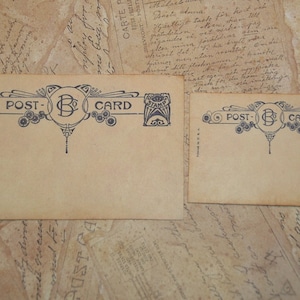 May include: Two vintage postcards with a beige background. The postcards have a decorative blue design with the words "POST-CARD" and a central "B" initial. The postcards are on a background of old paper.