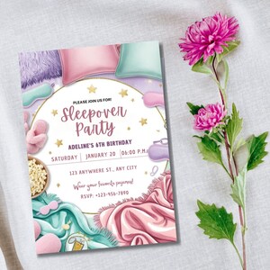 Pu&ograve; includere: Un invito bianco con stelle dorate e un'illustrazione rosa e blu di cuscini, una maschera per dormire e popcorn. Il testo sull'invito recita "Unisciti a noi per una festa in pigiama, il 6&deg; compleanno di Adeline, sabato 20 gennaio, 18:00, 123 Anywhere St., Any City, Indossa il tuo pigiama preferito! RSVP: -123-456-7890".