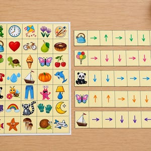 Pu&ograve; includere: Un colorato gioco educativo con carte illustrate raffiguranti vari oggetti e carte direzionali abbinate. Le carte includono immagini di un bollitore, un cuore, una bicicletta e altro ancora. Le carte direzionali hanno frecce.