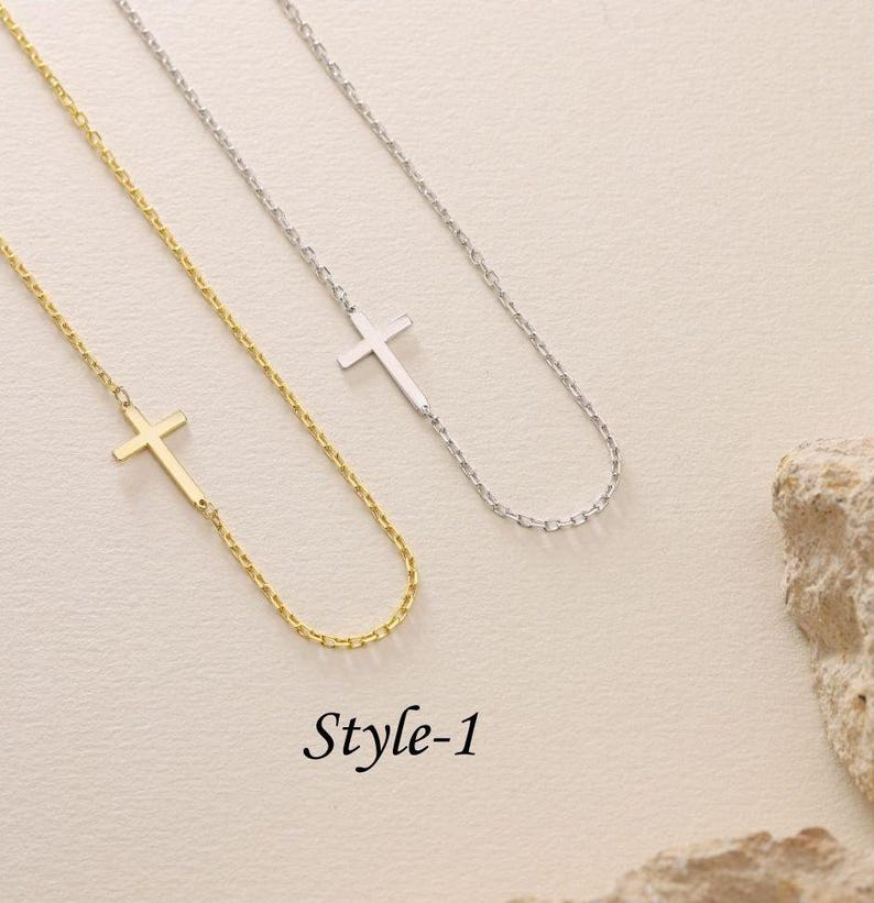 May include: Two delicate necklaces with a simple cross pendant. One necklace is gold and the other is silver. The necklaces are on a white background. The text "Style-1" is below the necklaces.