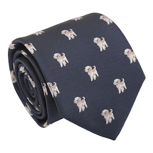 May include: A dark blue silk tie with a repeating pattern of small, white dogs. The tie is rolled up and ready to be worn.