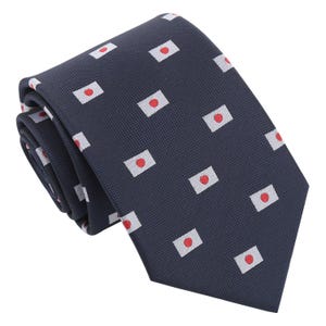Op de afbeelding: Een donkerblauwe stropdas met een herhalend patroon van de Japanse vlag. De vlag is wit met een rode cirkel in het midden.