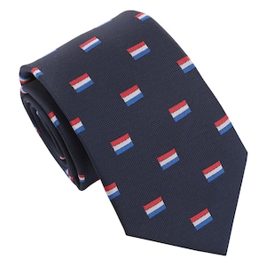 Op de afbeelding: Een donkerblauwe stropdas met een herhalend patroon van kleine rode, witte en blauwe vierkanten. De vierkanten lijken op de vlag van Nederland.