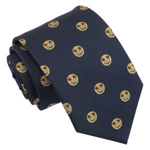 Op de afbeelding: Een donkerblauwe stropdas met een herhalend patroon van gele smiley-gezichten met rode ster-ogen.