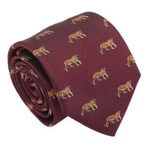 May include: A maroon silk tie with a repeating pattern of orange and black tigers.