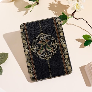 Peut inclure: Étui rectangulaire noir avec un design orné. L'étui présente un emblème central avec deux créatures vertes et dorées ressemblant à des hippocampes, entouré d'un motif géométrique doré. Les bords sont décorés de motifs floraux dorés et de détails marron.