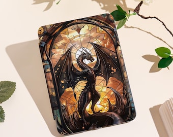 May include: A phone case featuring a stained-glass design with a dragon. The dragon is black and red, with large wings, set against a sunset background. The case has a protective design.