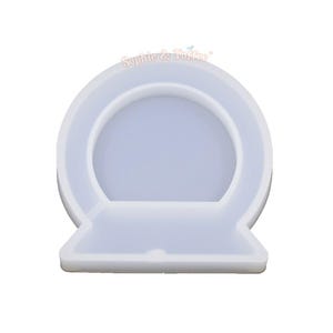 May include: A clear, flexible silicone mold in the shape of a snow globe. The mold has a rounded top with a flat base. The text "Sophie & Toffee" is printed on the top. Ideal for resin art and crafting projects.