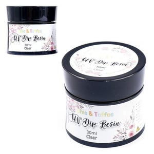 May include: Two black-lidded jars of UV Dip Resin are displayed. The labels feature the text "Sophie & Toffee UV Dip Resin" with floral accents. Each jar contains 30ml of clear resin. The jars are set against a white background.
