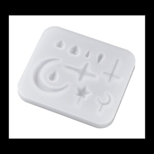 May include: White silicone mold with various shapes including a crescent moon, a star, a cross, a sword, and several teardrop shapes.