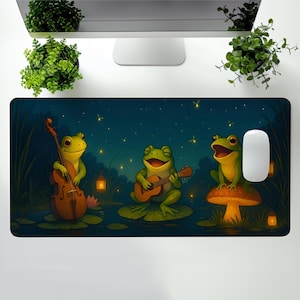 May include: A whimsical mousepad featuring three cartoon frogs playing musical instruments. One frog plays a cello, another a guitar, and the third sits on a mushroom. The background is a dark blue night scene with fireflies.