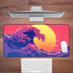 Pode incluir: Um tapete de mesa colorido com um grande design de onda em tons de azul, roxo e rosa. A onda é colocada contra um fundo de pôr do sol com um sol amarelo.