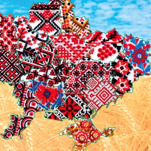 May include: A map of Ukraine is depicted with various regions filled with intricate, colorful beadwork patterns. The designs feature red, white, and black geometric and floral motifs, set against a backdrop of wheat and a blue sky.