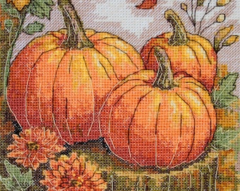 May include: Cross-stitch artwork featuring three orange pumpkins with green stems, surrounded by orange flowers and green foliage. The pumpkins are the focal point, with detailed stitching creating texture and depth. The overall theme is autumn and harvest.