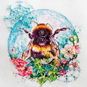 May include: A cross-stitch embroidery design featuring a bumblebee surrounded by flowers and a snowflake. The bumblebee is yellow, black, and brown, and the flowers are pink, white, and green. The snowflake is blue and white.