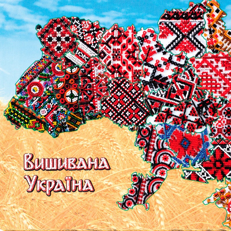 May include: A colorful map of Ukraine, intricately decorated with beadwork in red, black, white, and other colors. The map is set against a background of wheat and a blue sky. The text "Вышивана Україна" is displayed in the lower left corner.